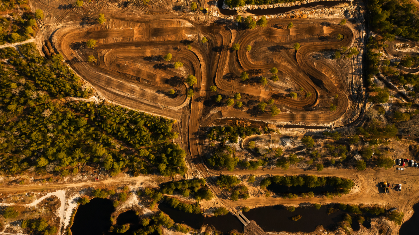Aerial view of Salty Acres motocross tracks, ponds and lodge at sunset